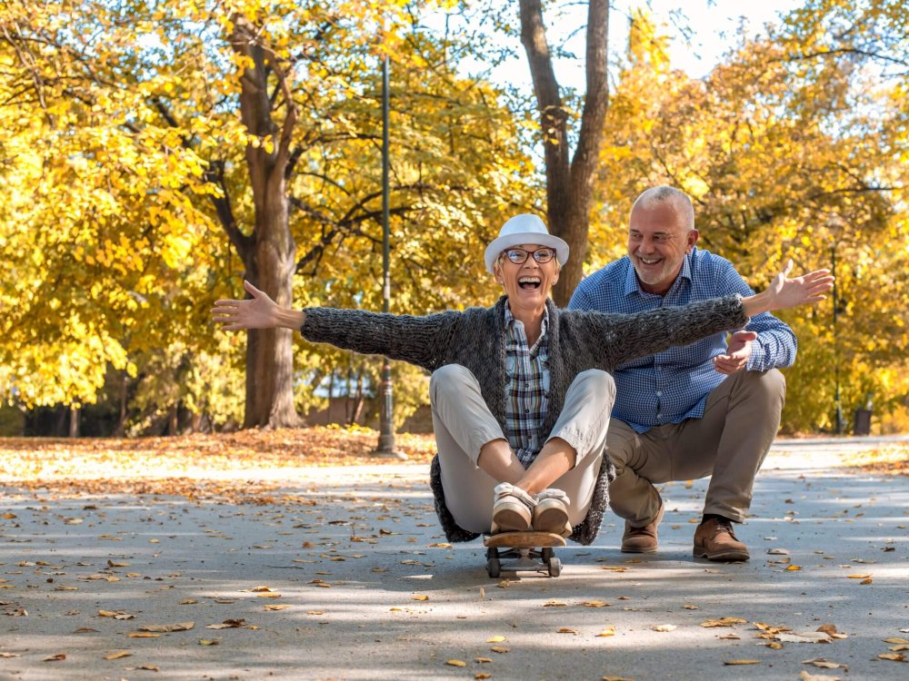 An elderly couple with a woman sitting on skate in the park